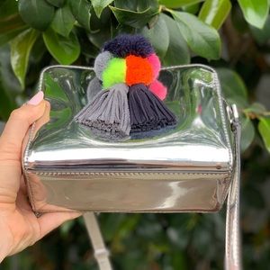 Silver mirror crossbody bag with pom poms and tassels